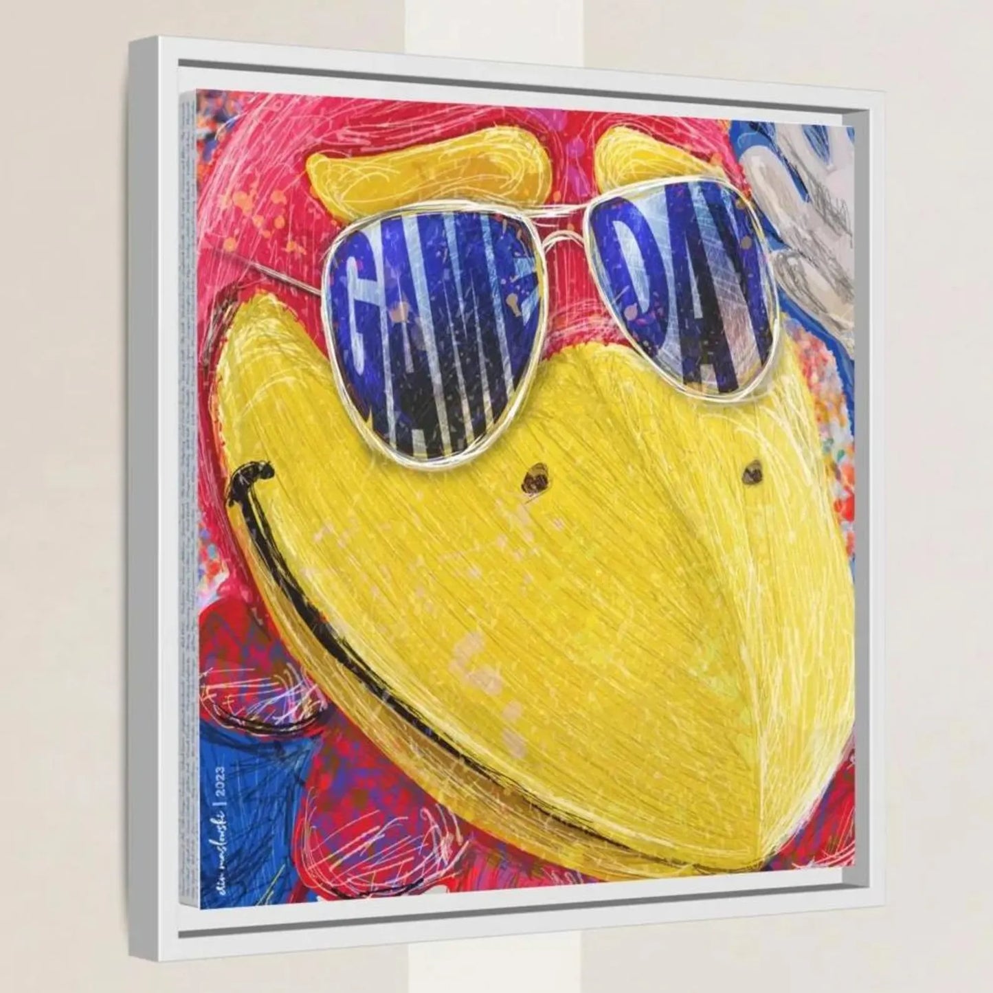 A framed artwork depicting a yellow bird wearing sunglasses with the word "GAME DAY" written on them.
