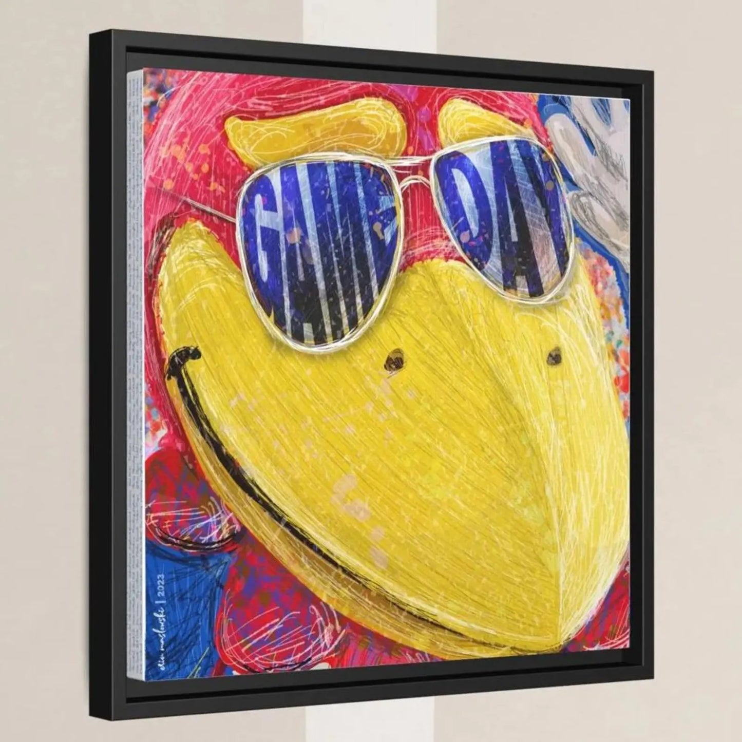A framed artwork depicting a colorful, abstract bird wearing sunglasses with the text "GAME DAY" written on it.