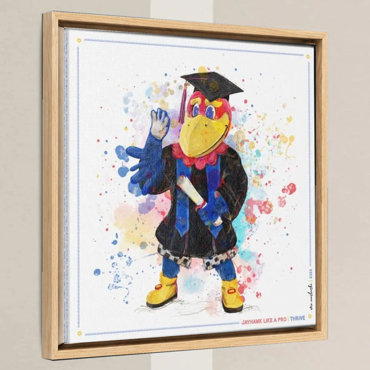 KU Jayhawk Thrive Art: University of Kansas Graduation Splatter Paint Canvas Print in a light oak float frame